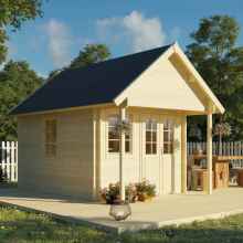 A log shed in a garden with an open gable roof style and bitumen roofing shingles. This wooden cabin has double wide half-glazed doors and wooden windows. The entire structure is built on a wooden deck, and there is a wooden table with benches. The surroundings are adorned with plants and flowers