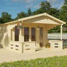 A log cabin with a spacious front deck, featuring large, long windows and fully glazed double-wide doors. The roof is in an open gable style, and the surroundings are adorned with plants and flowers.